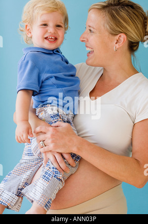 Donna incinta abbracciando il bambino Foto Stock