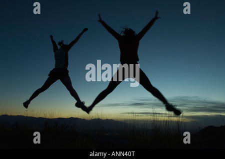 Silhouette di persone che saltano, saline, Utah, Stati Uniti Foto Stock