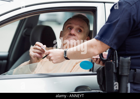 Il sergente di polizia controllando la patente di guida del conducente. Foto Stock