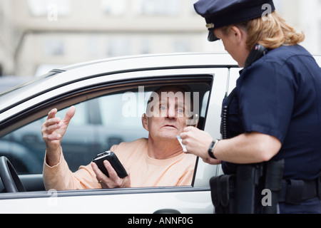 Donna funzionario di polizia controllando la patente di guida del conducente. Foto Stock