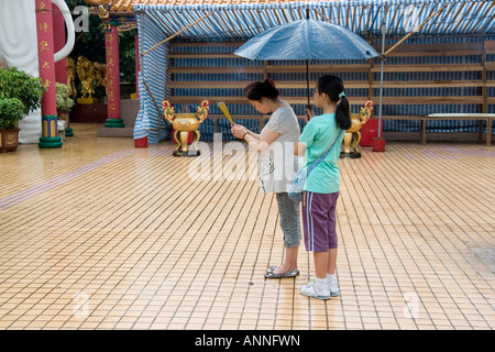 Asia sud-est Repubblica popolare cinese Hong Kong pregano fuori sotto la pioggia al tempio di Diecimila Buddha Foto Stock