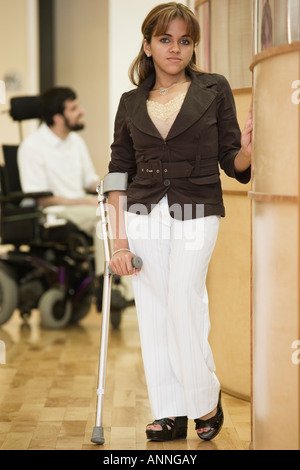 Ritratto di una donna disabile con un uomo seduto su una sedia a rotelle in background. Foto Stock