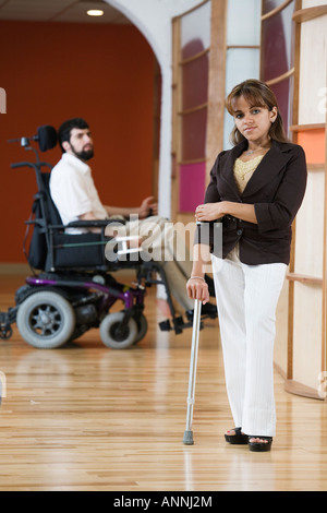 Ritratto di una donna disabile con uomo seduto su una sedia a rotelle in background. Foto Stock