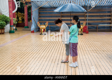 Asia sud-est Repubblica popolare cinese Hong Kong pregano fuori sotto la pioggia al tempio di Diecimila Buddha Foto Stock