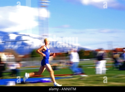 Una scuola di atleta concorrenti a un track meet in Salt Lake City, Utah, Stati Uniti d'America. Egli è il leader in un lungo ed estenuante percorso di gara. Foto Stock