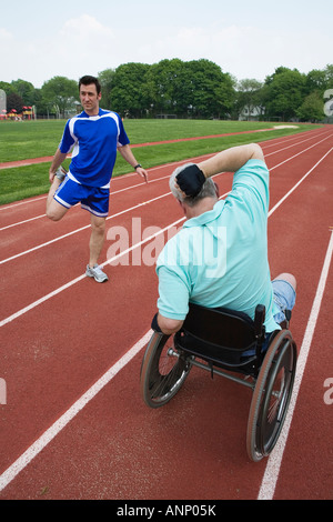 Il giovane e un handicap uomo senior esercitando su di una pista. Foto Stock