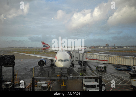 British Airways aerei attraccata a heathrow terminal in un giorno di pioggia Foto Stock