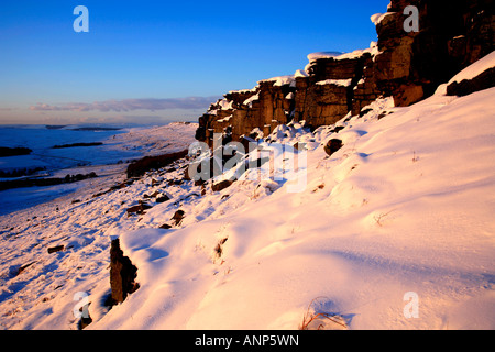 Il tardo inverno tramonto su un nevoso bordo Stanage Parco Nazionale di Peak District Derbyshire England Regno Unito Regno Unito Foto Stock
