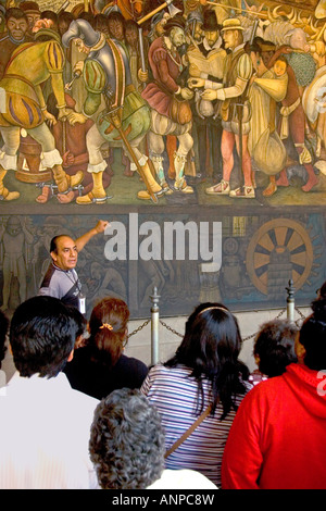 Una guida turistica che mostra ai turisti un murale dipinto da Diego Rivera presso il Palazzo Nazionale a Città del Messico MESSICO Foto Stock
