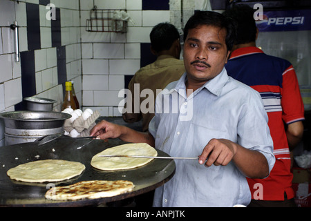 Un cuoco prepara un preferito piatto Bengali, Kathi rotoli su un tawa in Park Street, Calcutta, India. Foto Stock
