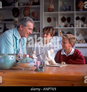 Nota insegnante di classe e junior gli studenti discutono un progetto in classe Foto Stock