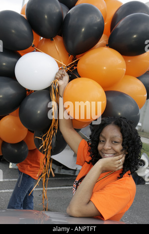 Miami Florida,Overtown,Booker T. Washington High School,campus,public Education,campus,state football Champions balloons,Orange,Black femmina,teen teen Foto Stock