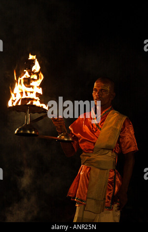 Brahman sacerdote Indù durante il quotidiano cerimonia serale presso le rive del fiume Gange a Varanasi, India Foto Stock