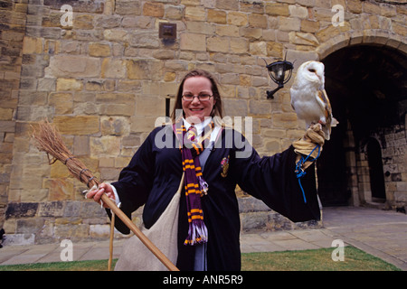 Tour femminile guida vestita come Harry Potter a Alnwick Castle in Northumberland detiene un barbagianni sulla sua mano Foto Stock