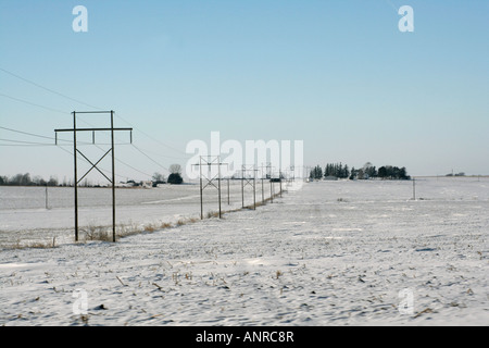 Rural linee di trasmissione di potenza elettrica in inverno Foto Stock