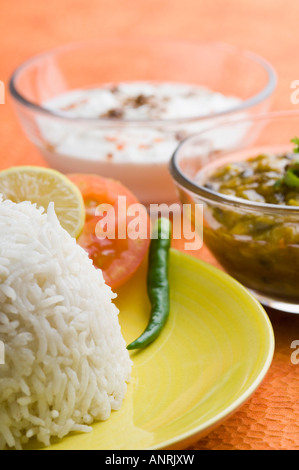 Close-up di riso in una piastra con il curry di ceci e rayta Foto Stock