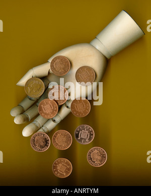 Un penny monete cadere dalla mano di legno, close-up Foto Stock