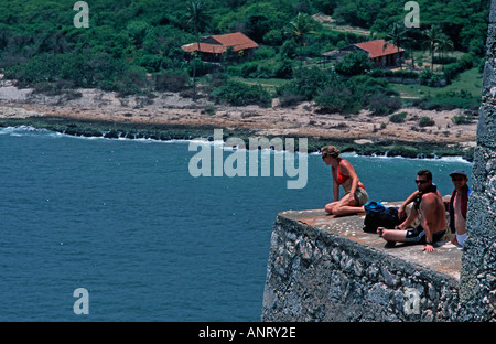 Gruppo di turisti che si siedono sul bordo di una parete a El Morro fortezza Santiago de Cuba Cuba Foto Stock