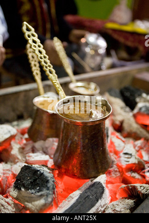 Tradizionale caffè turco in ebollizione tre vasi di caffè turco di essere preparati in modo tradizionale su carbone incandescente Foto Stock