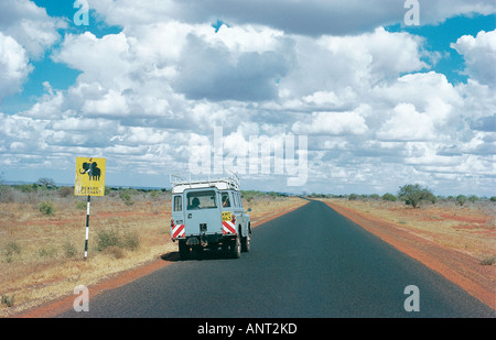 Landrover parcheggiato sul principale Nairobi Mombasa road accanto la strada della lettura del segno ATTENZIONE ELEPHANT Kenya Africa orientale Foto Stock