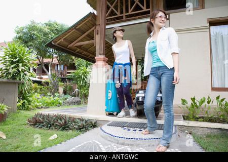 Due giovani donne che portano le valigie Foto Stock