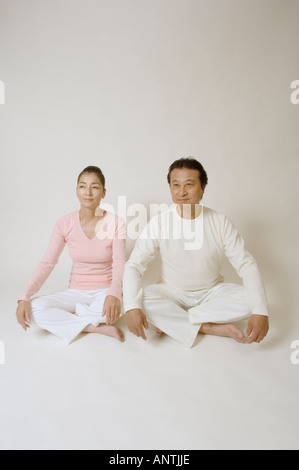 Coppia matura seduta con le gambe incrociate Foto Stock