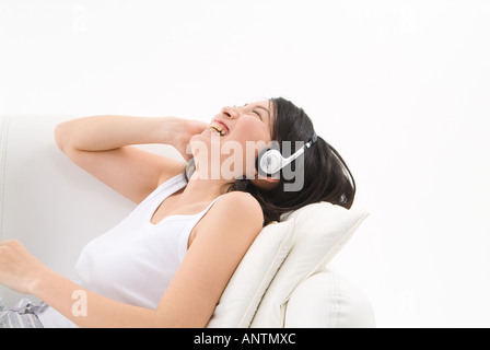 Giovane donna che indossa le cuffie Foto Stock