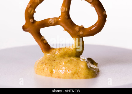 Una cotta al forno Pretzel ritorto con un tuffo di senape Foto Stock