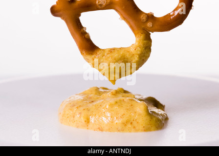 Una cotta al forno Pretzel ritorto con un tuffo di senape Foto Stock