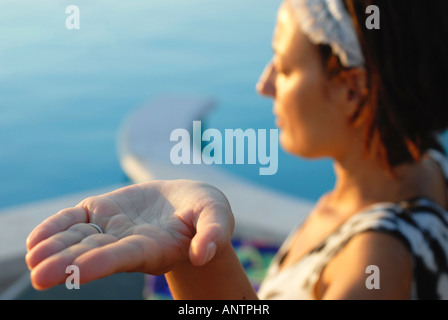Una donna pratica di una posizione di yoga con aprire palm mano Foto Stock