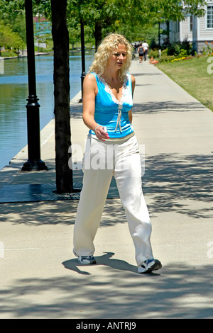 Blonde lavoratore di sesso femminile che indossa scarpe da jogging nel suo lunchbreak Foto Stock