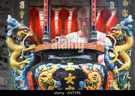 L'uomo brucia incenso al tempio Kuantu , Taipei Foto Stock