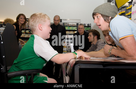 Danny Jones da McFly boy band con una giovane ventilatore disattivato Foto Stock