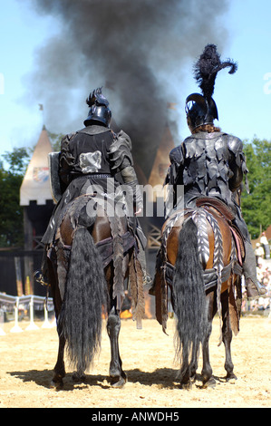 Due cavalieri neri da dietro seduti nei loro cavalli, sullo sfondo nuvola nera di fumo, cavaliere Kaltenberger festival Foto Stock