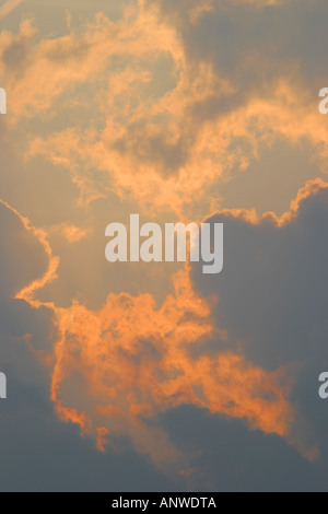 Raggi solari del tramonto incandescente attraverso le nuvole scure al tramonto di sera Foto Stock