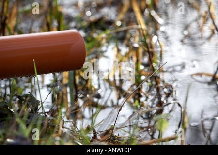Acqua in plastica del tubo di troppopieno spuntavano in fiume Foto Stock