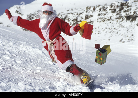 Babbo Natale con i regali di Natale su uno snowboard, Alpi Foto Stock