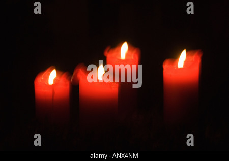Quattro candele rosse su una corona di Avvento Foto Stock