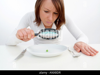 Donna con lente di ingrandimento visualizzato il segnale di PEA in corrispondenza della piastra Foto Stock