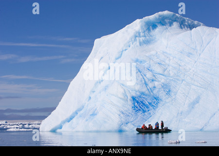 L'Antartide, i visitatori possono ottenere uno sguardo ravvicinato di un enorme iceberg da una piccola barca usata per traghetti passeggeri a riva Foto Stock