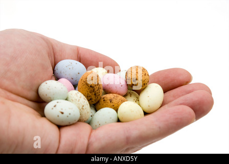 Mano che tiene le piccole uova Easter candy Foto Stock