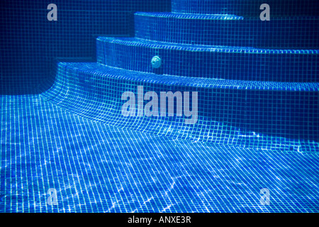 Passaggi curvi con riflessioni su un mosaico affiorato piscina Foto Stock