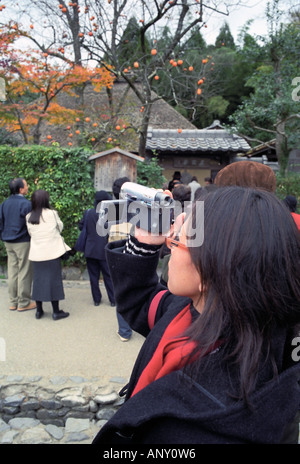 Donna di nastratura video al di fuori di un tempio a Kyoto in Giappone Foto Stock