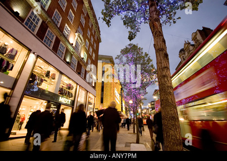 Oxford street double decker e decorazione di Natale,debenhams in distanza nella serata di Londra Foto Stock