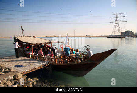 Un tradizionale dhow di legno ormeggiate e tenendo sui passeggeri per un partito flottante, Abu Dhabi, Emirati arabi uniti Foto Stock