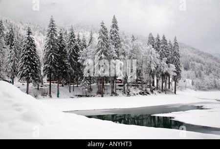 Chalet solitario sul Lac de Montriond, parzialmente ghiacciato in inverno con la neve tutto intorno, alpi, Francia Foto Stock