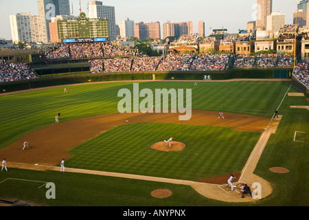 ILLINOIS Chicago folla in gabbie Wrigley Field guardando night game stadium Chicago Cubs squadra di baseball gradinate e del quadro di valutazione Foto Stock