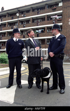 Ex Home Secretary David Blunkett ha affiancato da ufficiali della polizia durante un aborigeno su un alloggiamento di Lambeth estate London REGNO UNITO Foto Stock