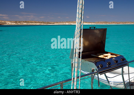 Cucina di pesce sul barbecue su barca ormeggiata in laguna di Ningaloo Reef Marine Park Western Australia n. PR Foto Stock