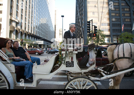 ILLINOIS Chicago per un paio di equitazione in carro trainato da cavalli nel centro commerciale del distretto Magnificent Mile e Michigan Avenue Foto Stock